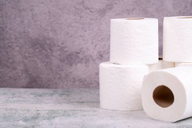 Tuvalet kağıdı. Tuvalet kağıdı gri arka planda yuvarlanıyor. Boşluğu kopyala