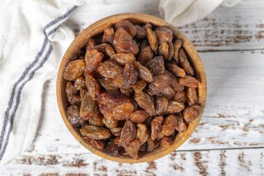 Ahşap arka planda doğal kurumuş üzümler. Sağlıklı beslenme ve alternatif çöl için meyveli atıştırmalık. Üst görünüm