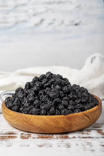 stock image Natural dried blueberry grains in bowl on wooden background. Fruit snack for a health diet and alternative desert. Close up