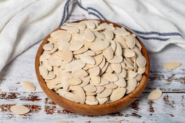 Tahta kasede kabak çekirdeği. Beyaz ahşap arka planda kabak tohumları