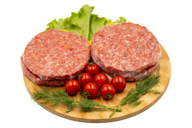 Beyaz arka planda çiğ hamburger köftesi. Çiğ dana burger köfteleri, otlar ve baharatlar. Kapat.