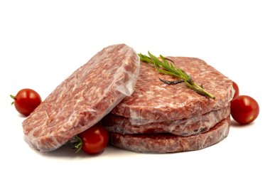 Beyaz arka planda çiğ hamburger köftesi. Çiğ dana burger köfteleri, otlar ve baharatlar. Kapat.