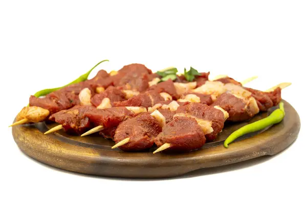 Beef tenderloin skewer isolated on white background. Beef tenderloin skewer with raw sauce with herbs and spices. Close up