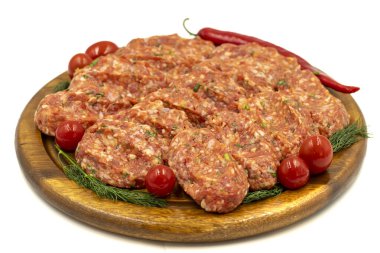 Köfteler beyaz arka planda izole edilmiş. Çiğ et köftesi, baharatlı ve otlu.