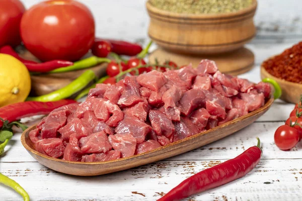 Beef cubed on wood background. Raw beef cubed with herbs and spices