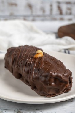 Çikolatalı ve fıstıklı kek. Tabakta taze karamelli fıstık keki. Kapat.