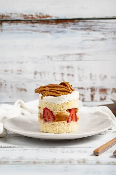 Strawberry and caramel cake. Fresh cake with caramel and strawberries on a plate