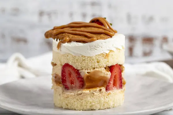 Strawberry and caramel cake. Fresh cake with caramel and strawberries on a plate. Close up