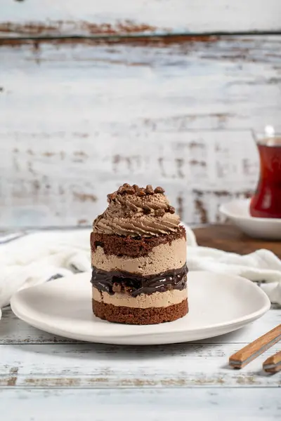 Chocolate and cocoa cake. Layer cake with fresh chocolate cream on a plate