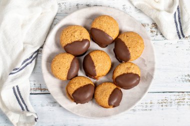 Çikolatalı kurabiye. Tahta zemin üzerinde badem unuyla pişirilmiş çikolatalı kurabiyeler. Pastane ürünleri. Üst görünüm