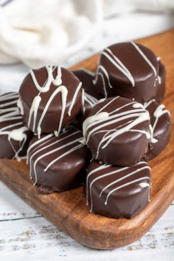 Çikolatalı kurabiye. İçi hindistan cevizli, dışı çikolatalı ve ahşap kaplamalı lezzetli kurabiyeler. Pastane ürünleri. Kapat.