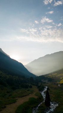 Ormanlarla kaplı bir dağ. Hava manzaralı orman ve nehir. Dağ sırası doğal koruma alanıdır. Gün batımında orman manzarası
