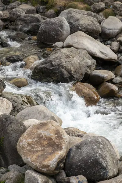 Water flows among the stones. Flow of water and stones. Stones in flowing water. Water conservation concept