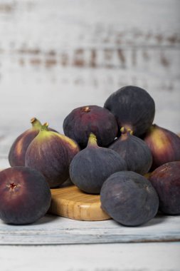 Beyaz ahşap arka planda taze incirler. Organik tarım ürünleri. Lezzetli siyah incirler. Kapat.