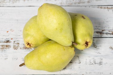 Beyaz ahşap arka planda taze armutlar. Organik tarım ürünleri. Lezzetli olgun armutlar.