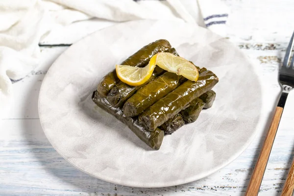 Stuffed grape leaves with olive oil. Turkish cuisine delicacies. Delicious stuffed grape leaves on a white background