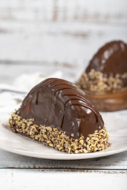 Çikolata ve muzlu pasta. Ahşap arka planda Malaga keki. Büyük çikolata ekleriName