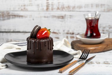 Çikolatalı pasta. Çilekli kek, bisküvi parçacıkları ve ahşap bir arka planda çikolata.