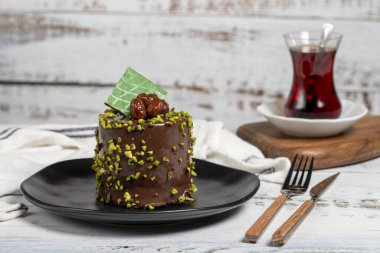 Fıstıklı kek. Beyaz arka planda çikolata ve şam fıstıklı kek.