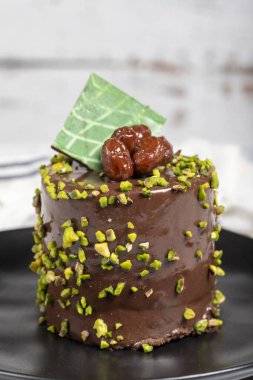 Fıstıklı kek. Beyaz arka planda çikolata ve şam fıstıklı kek.