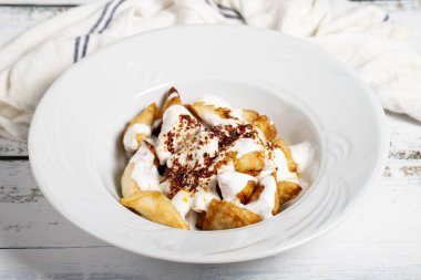 Türk mantısı. Beyaz arka planda yoğurt ve soslu Ravioli.