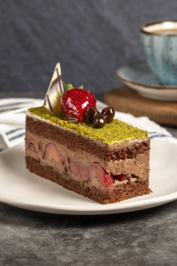 Fıstıklı kek. Koyu arkaplanda çilekli ve şam fıstıklı kek. Kapat.