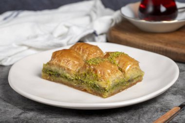 Fıstıklı baklava. Karanlık bir arka planda fıstıklı baklava. Türk mutfağı aromalı. Kapat.