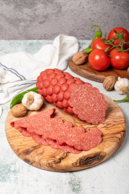 Kesme tahtasındaki sosis ve dilimler. Gri arka planda soğuk sosis dilimleri