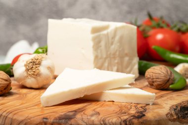 Tam yağlı inek peyniri. Kesme tahtasındaki taze inek peyniri. Kapat.