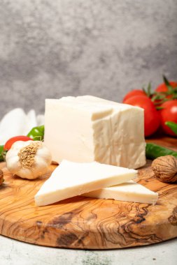 Tam yağlı inek peyniri. Kesme tahtasındaki taze inek peyniri. Kapat.