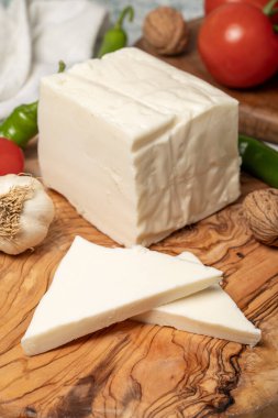 Tam yağlı inek peyniri. Kesme tahtasındaki taze peynir. Kapat.