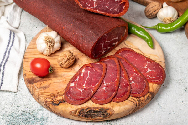 Turkish pastrami. Traditional Turkish cuisine flavors. Bacon slices on cutting board. Local name sivas pastirma