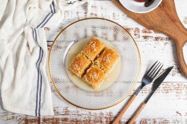 Sütlü Baklava. Beyaz arka planda fındıklı süt baklavası. Yerel adı Sutlu Nuriye Baklava. Kapat.