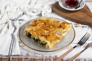 Ispanaklı börek. Hamur işi ürünü. Beyaz arka planda ıspanaklı turta. Yerel adı ispanakli borek