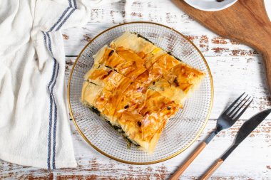 Ispanaklı börek. Hamur işi ürünü. Beyaz arka planda ıspanaklı turta. Yerel adı ispanakli borek. Üst görünüm