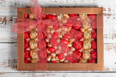 Paketli çikolata kutusu. Hamur işi ürünü. Beyaz arka planda çeşitli çikolatalarla hazırlanmış hediye çikolata kutusu. Üst görünüm