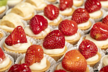 Turta seven tipler. Hamur işi ürünü. Beyaz arka planda kivili, muzlu ve çilekli tart. Yerel bir isim. Kapat.