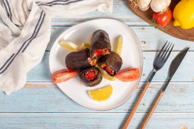Pirinçle doldurulmuş patlıcan. Aperatif yemekler. Mavi ahşap arka planda zeytinyağlı patlıcan dolması. yerel adı Patlican dolmasi