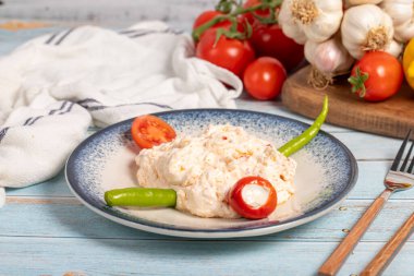 Zeytinyağı ve baharatlı aperatif. Aperatif yemekler. Mavi ahşap zemin üzerinde baharatlı yoğurt bulunan atom tabağı. yerel adı atom mezesi