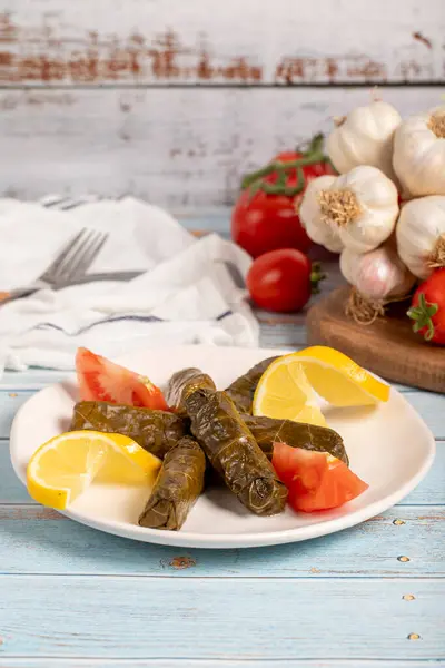 Stuffed grape leaves with olive oil. Appetizer dishes. Stuffed stuffed leaves with meat on a blue wooden background. local name yaprak sarma. Close up