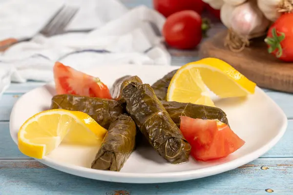 Stuffed grape leaves with olive oil. Appetizer dishes. Stuffed stuffed leaves with meat on a blue wooden background. local name yaprak sarma. Close up