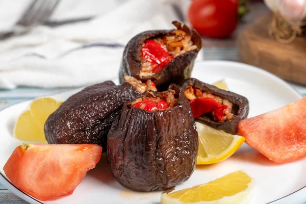 Eggplant stuffed with rice. Appetizer dishes. Stuffed eggplant with olive oil on a blue wooden background. local name patlican dolmasi