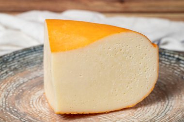 Gouda peyniri. Süt ürünleri. Tabakta Gouda peyniri dilimleri. Kapat.