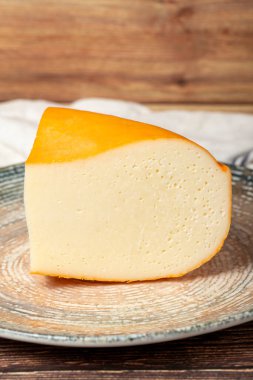 Gouda peyniri. Süt ürünleri. Tabakta Gouda peyniri dilimleri. Kapat.