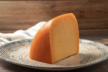 Mimolette peyniri. Süt ürünleri. Tabakta Mimolette peyniri dilimleri