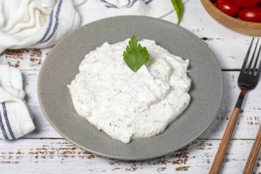 Haydari mezze. Geleneksel Asya tatları. Yoğurt ve nane ile taze bir atıştırmalık. Beyaz ahşap arka planda Haydari aperatifi. Kapat.