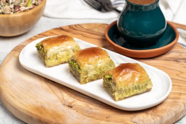 Türk baklavası. Akdeniz mutfağı aromalı. Kırsal masada Türk kahvesi, ramazan ya da bayram tatlıları konsepti olan şam fıstıklı baklava. Kapat.