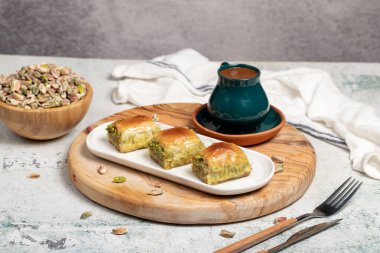 Kırsal masada Türk kahvesi, ramazan ya da bayram tatlıları konsepti olan şam fıstıklı baklava. Orta Doğu mutfağı tatları