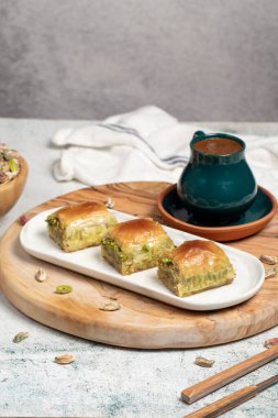 Kırsal masada Türk kahvesi, ramazan ya da bayram tatlıları konsepti olan şam fıstıklı baklava. Orta Doğu mutfağı aromalı. Kapat.