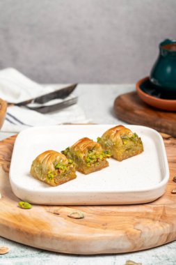 Cimcik baklava. Akdeniz mutfağı aromalı. Kırsal masada Türk kahvesi, ramazan ya da bayram tatlıları konsepti olan şam fıstıklı baklava. Kapat.